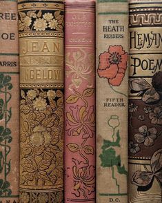 old books are lined up in rows on a shelf, with flowers and leaves painted on them