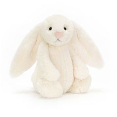 a white stuffed rabbit sitting up against a white background