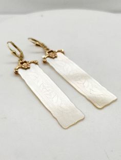 Chinese gaming counters became incredibly popular in the late 1800's and were often adorned with hand carved family crests or initials.  These beautiful counters are made from Mother of Pearl and are etched with delicate floral patterns and set on custom 14k yellow gold bails.  Lever back closures gives additional security as well as nice movement with these delicate dangle earrings! Elegant Carved Earrings For Formal Occasions, Elegant Carved Drop Earrings, Antique Carved Yellow Gold Jewelry, Vintage Carved White Gold Jewelry, Victorian Hallmarked Earrings For Ceremonial Occasions, Antique Carved Jewelry For Anniversary, Victorian Brass Earrings For Ceremonial Use, Victorian Brass Earrings For Ceremonial Occasions, Classic Intaglio Earrings As A Gift