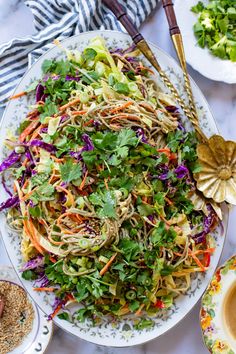 a large plate filled with salad next to other plates and utensils