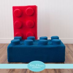 a blue and red couch sitting on top of a hard wood floor next to a white wall