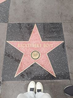 a person standing in front of a star on the hollywood walk of fame