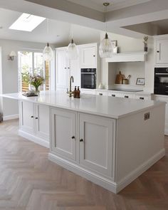 a large white kitchen with an island in the middle