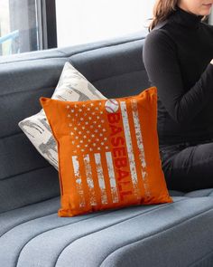 a woman sitting on a couch with an american flag pillow