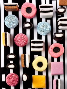 several different types of donuts on a black and white striped surface