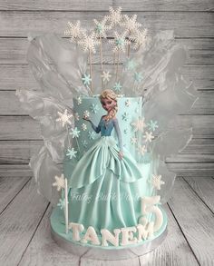 a frozen princess birthday cake with frosting and icing on the top, surrounded by snowflakes