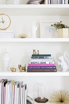 the shelves are filled with books and vases