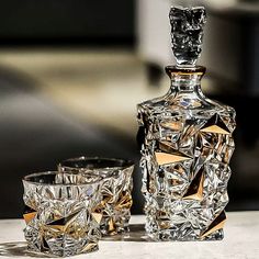 a crystal decanter and two shot glasses on a table