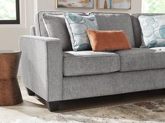 a gray couch with pillows on it in a living room