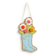 a wooden hanging decoration with flowers in a boot