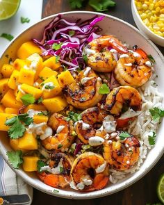 a white bowl filled with shrimp, rice and mango salsa next to corn on the cob