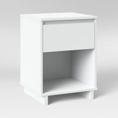 a white nightstand with an open shelf on the bottom and one drawer at the top