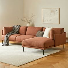 a living room with an orange couch and white rug