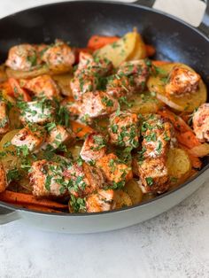 a skillet filled with potatoes and shrimp