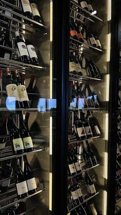 there are many wine bottles in the glass case