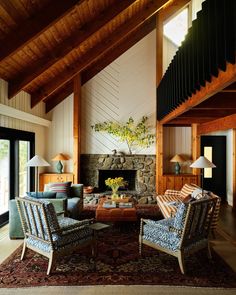 a living room filled with furniture and a fire place in the middle of an open floor plan