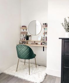 a green chair sitting in front of a mirror on top of a wooden dresser next to a white rug