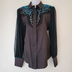 Showcase your unique style with this vintage Western shirt, featuring intricate embroidery and sheer sleeves. Perfect for making a bold fashion statement. * Button-up front * Embroidered yoke * Sheer sleeves * Double-button cuffs  * Made in the USA Size: Womens M Measurements taken flat Shoulders 16 in Bust 19.75 in Length 29 in Sleeve Length 26 in No stains or holes.  western, rodeo, cowgirl, horse show, bling, glam, cosplay, costume, retro, vintage, 80s, Fitted Long Sleeve Blouse With Embroidered Cuffs, Fitted Long Sleeve Shirt With Embroidered Cuffs, Embroidered Fitted Shirt For Fall, Bohemian Fitted Shirt With Buttons, Fitted Long Sleeve Shirt With Embroidery, Fitted Long Sleeve Embroidered Shirt, Fitted Shirt With Embroidered Long Sleeves, Bohemian Fitted Embroidered Shirt, Cowgirl Horse