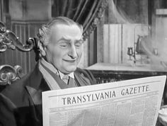 a man sitting in a chair reading a newspaper