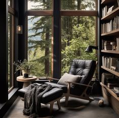 a chair and ottoman in front of a large window with trees outside the window on both sides