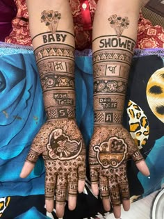 two hands with henna tattoos on them and the words baby shower written in arabic