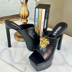 Authentic Versace Black La Medusa Leather Platform Mules These 140mm Black Stiletto-Heeled Mules Are Synonymous With Versace's Bold And Glamourous Style. This Pair Is Defined By Its Gold-Tone Medusa Plaque Which Represents An Emblem Of Beauty, Power And Strength To The Italian House. Crafted From Supple Leather, The Design Is Complete With A Dramatic Platform Sole. They Are A European Size 27.5 And Are In Excellent Condition With Minimal Wear To The Outer Sole From Being Worn 2-3 Times. They Do Italian House, Platform Mules, Versace Shoes, Black Stilettos, Glamorous Style, Shoe Box, Heeled Mules, Versace, Gold Tones