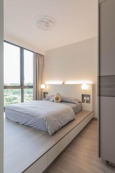 a large bed sitting in the middle of a bedroom next to a tall glass window