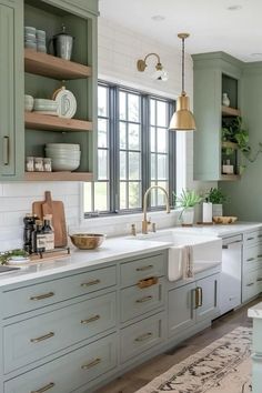 a kitchen with green cabinets and white counter tops, gold faucet, brass accents