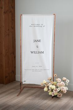 a bouquet of flowers sitting on top of a wooden floor next to a white banner