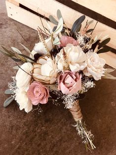 a bridal bouquet sitting on top of a wooden bench