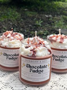 three candles with chocolate fudge toppings are on a table