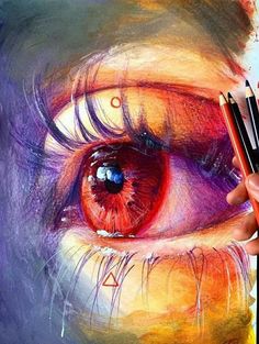 a person holding two colored pencils in front of a drawing of an orange eye