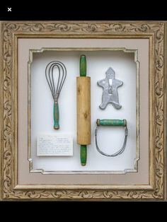 an old framed shadow box with various kitchen utensils and cookie cutters in it