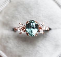 an engagement ring with a blue stone surrounded by white and pink diamonds on a cloth