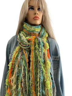 Enchanted Forest, Beautiful shades of green, orange, and blue.Gorgeous 90 inches long fringe scarf, Christmas gift This scarf is called Enchanted Forest. I have made more forest-themed scarves in the past, but no two scarves are alike, and this one pops out with its vibrant colors that would surprise you in the forest. Unfortunately, people often don't get to go to the forest as much as they want. Smell the greenery and feast on the forest's color. Nature makes us feel at home, and it also soothes our senses. I made this fringy scarf with various shades of forest green, and I had nothing but nature in my mind. It has 73 strands of mixed textured yarn in it.  The scarf is about 90 inches long; however, the middle 20 inches are sewn together to make a soft 7-inch-wide fabric. Therefore, ther Green Bohemian Scarf For Fall, Handmade Green Winter Scarves, Handmade Green Winter Scarf, Handmade Green Scarf For Winter, Green Bohemian Scarf One Size, Forest Color, Textured Yarn, Long Fringe, Long Fringes