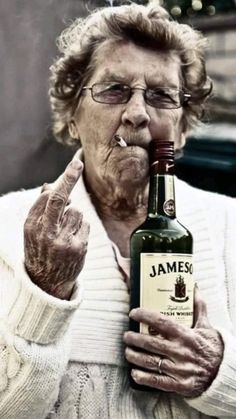 an old woman holding a bottle of jameson