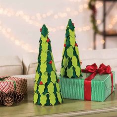 two paper christmas trees sitting on top of a table