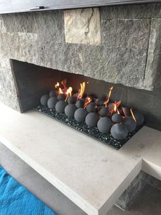 a fireplace that has some balls on it and is lit by the fire in front of it