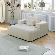 a living room with a couch, rug and window sill on the floor in front of it