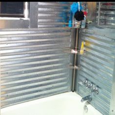 a bathroom with a tub, shower head and shelves