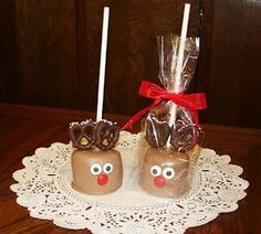 two chocolate covered candies on a doily with candy eyes and noses wrapped in cellophane