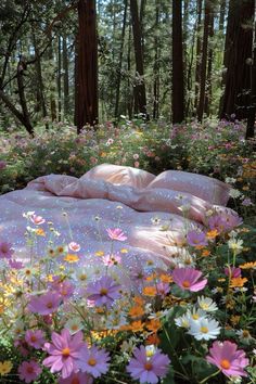 there is a pink blanket in the middle of some wildflowers and daisies