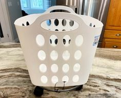 a white laundry basket sitting on top of a kitchen counter