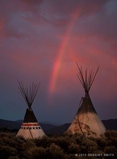 two teepees with a rainbow in the background