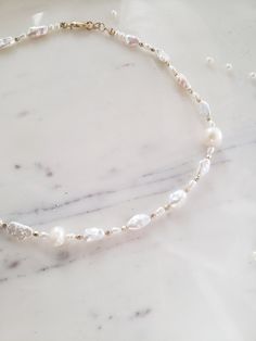 This gorgeous and unique necklace features natural freeform biwa Pearl's and freshwater Pearl's of all shapes and sizes for a high end custom effect. Faceted metal beads are spaced throughout for shimmer and shine. ✨ Handmade from top quality materials, 925 sterling silver or 14k gold fill. Gold fill is much higher quality than gold plated jewelry and contains 100 times more gold! People with highly sensitive skin can usually wear gold fill with no problems. Hypoallergenic, lead and nickel free. Delicate Baroque Pearl Bracelet With Pearl Chain, Delicate Baroque Pearl Chain Bracelet, Delicate Baroque Pearl Bracelet, Baroque Pearl Choker Necklace In Pearl White, Pearl White Baroque Pearl Choker Necklace, Baroque Pearl White Choker Necklace, Dainty Single Strand Akoya Pearl Necklace, Dainty Akoya Pearl Single Strand Necklace, Baroque Pearl Choker Necklace With Pearl Charm