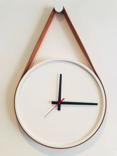 a clock hanging from the side of a wall with a triangle on it's face