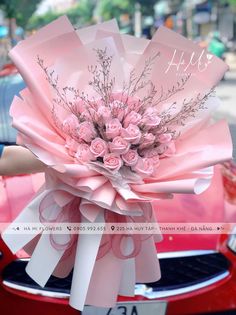 a bouquet of pink roses on the hood of a car