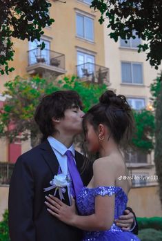 a man and woman in formal wear kissing each other