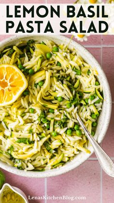 lemon basil pasta in a bowl on a pink tiled surface with two spoons next to it