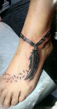 a person with a tattoo on their foot that has a feather and words written on it